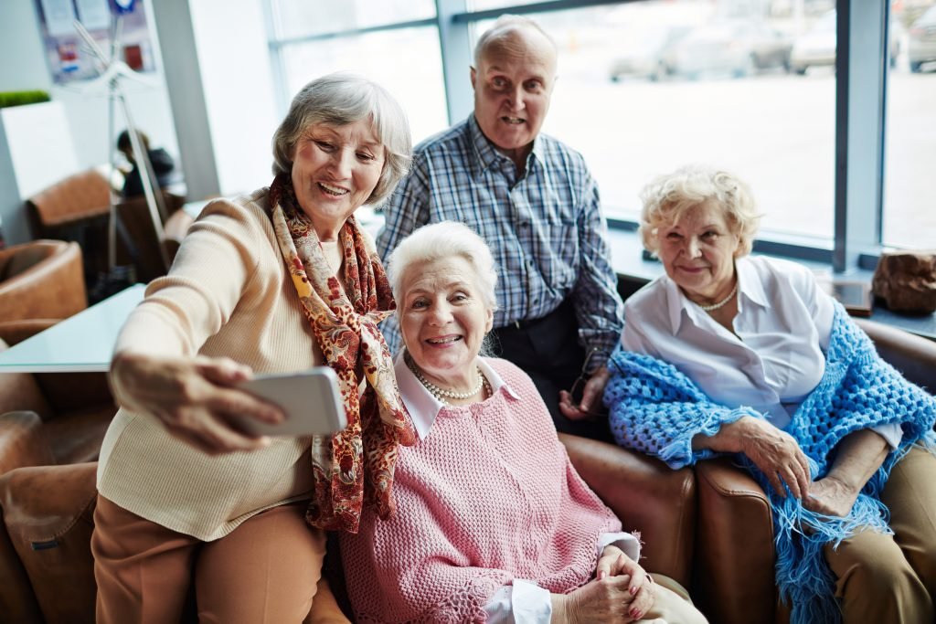 quatre seniors qui prennent un selfie ensemble