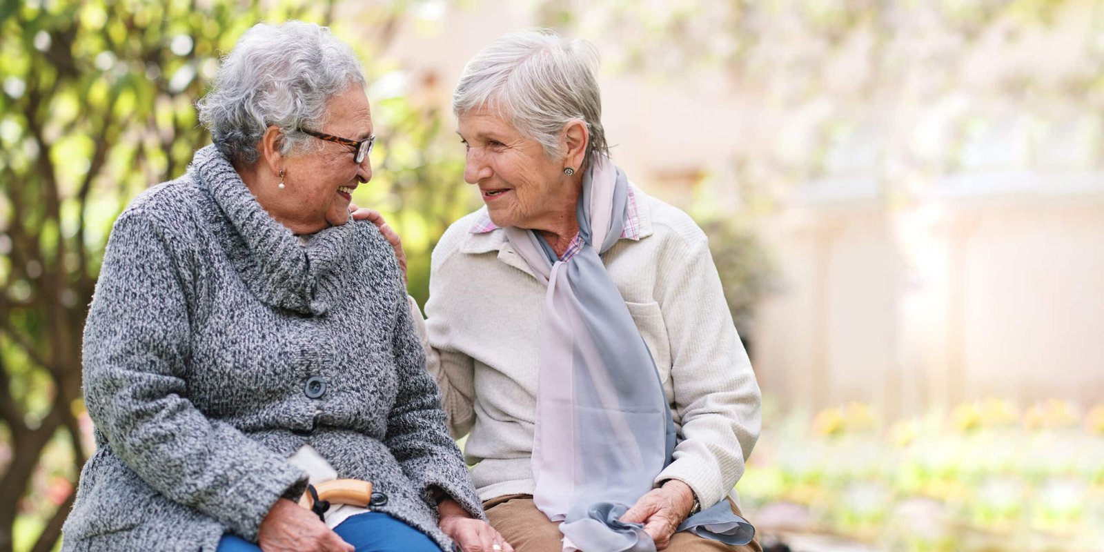 Deux amis seniors discutant dans le jardin de la résidence senior Nohée.